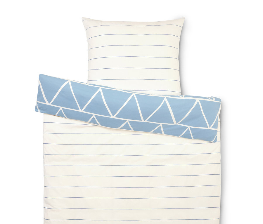 Zestaw pościeli z białymi i niebieskimi paskami, poszewka na poduszkę i niebieski wałek z białymi trójkątami.