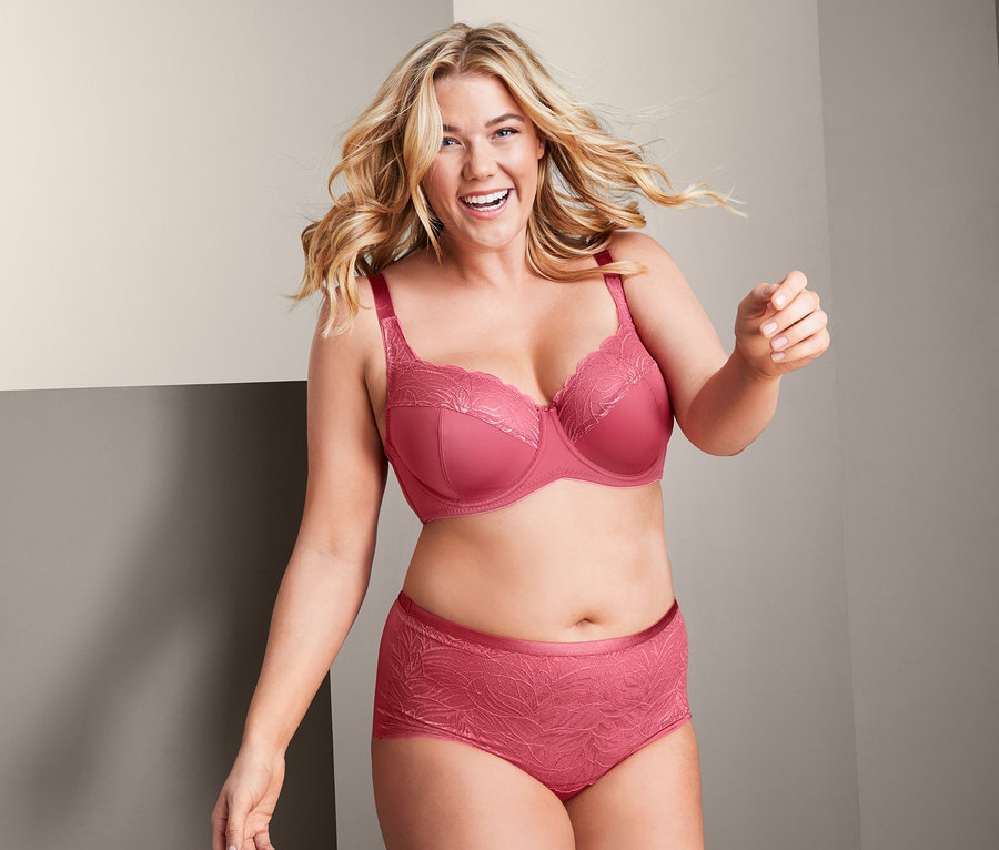 Kobieta ma na sobie biustonosz z fiszbinami i figi modelujące.