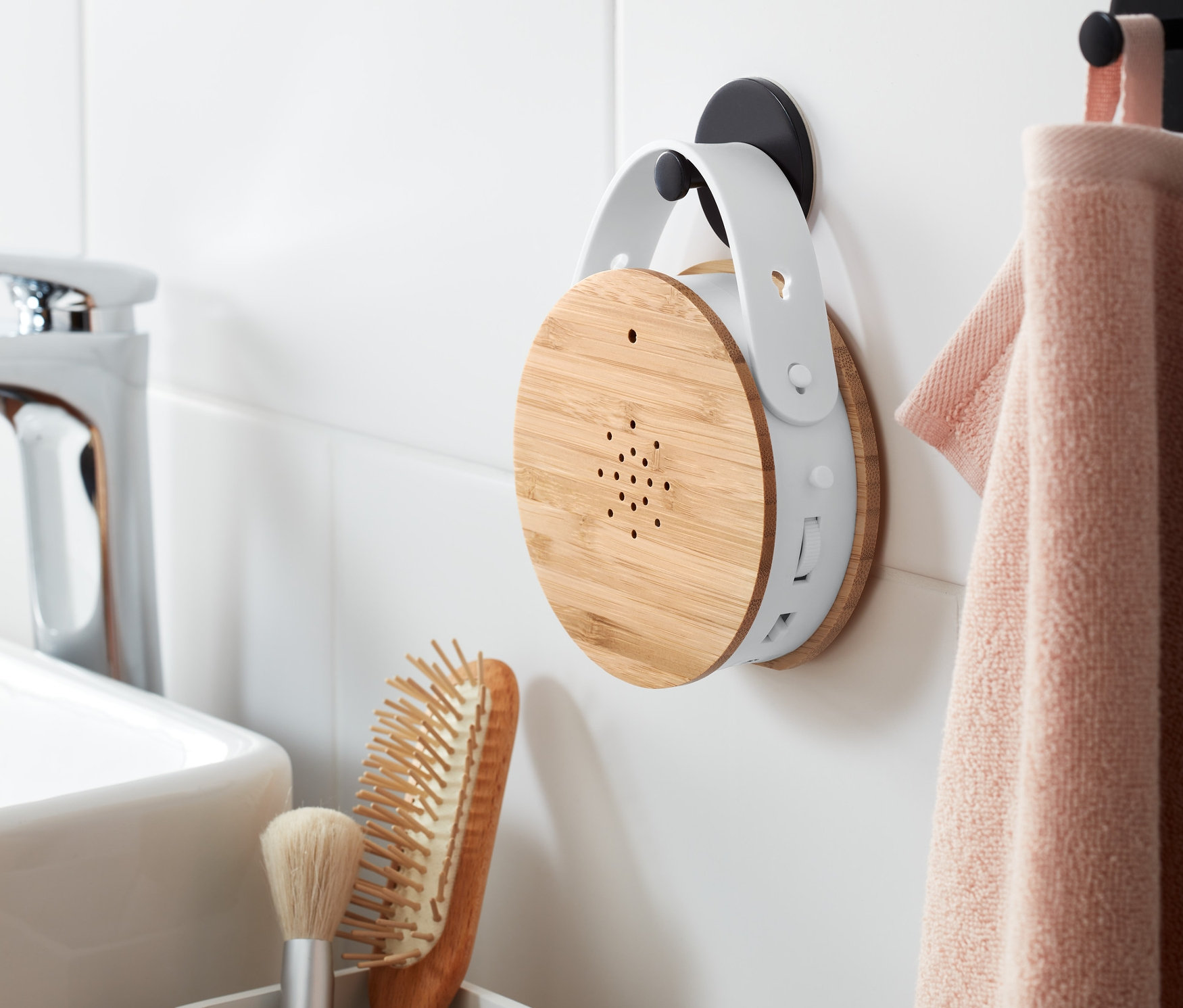 Odtwarzacz śpiewu ptaków wisi na ścianie obok ręcznika.