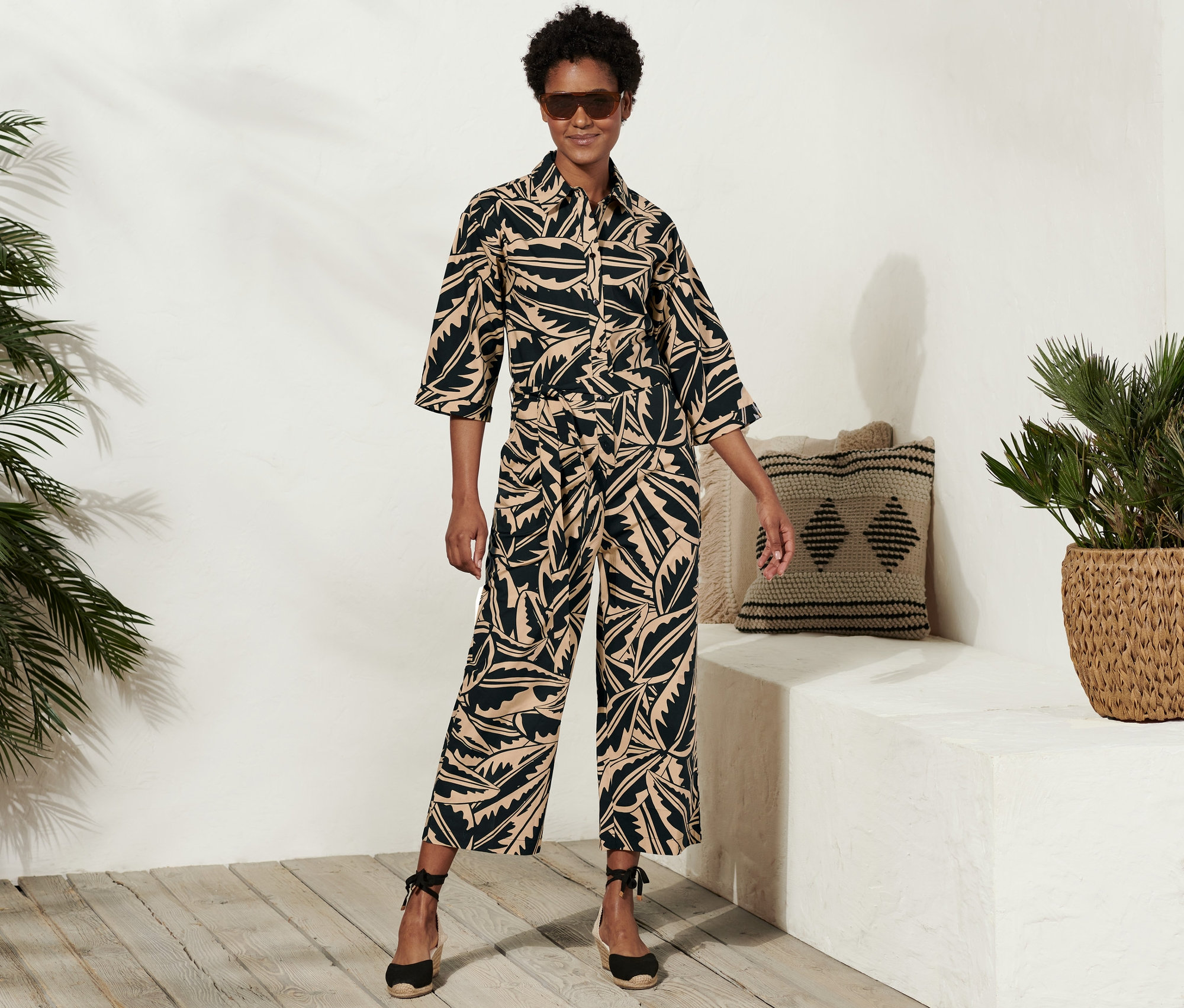 Kobieta pozuje w kombinezonie z popeliny z nadrukiem na całej powierzchni.