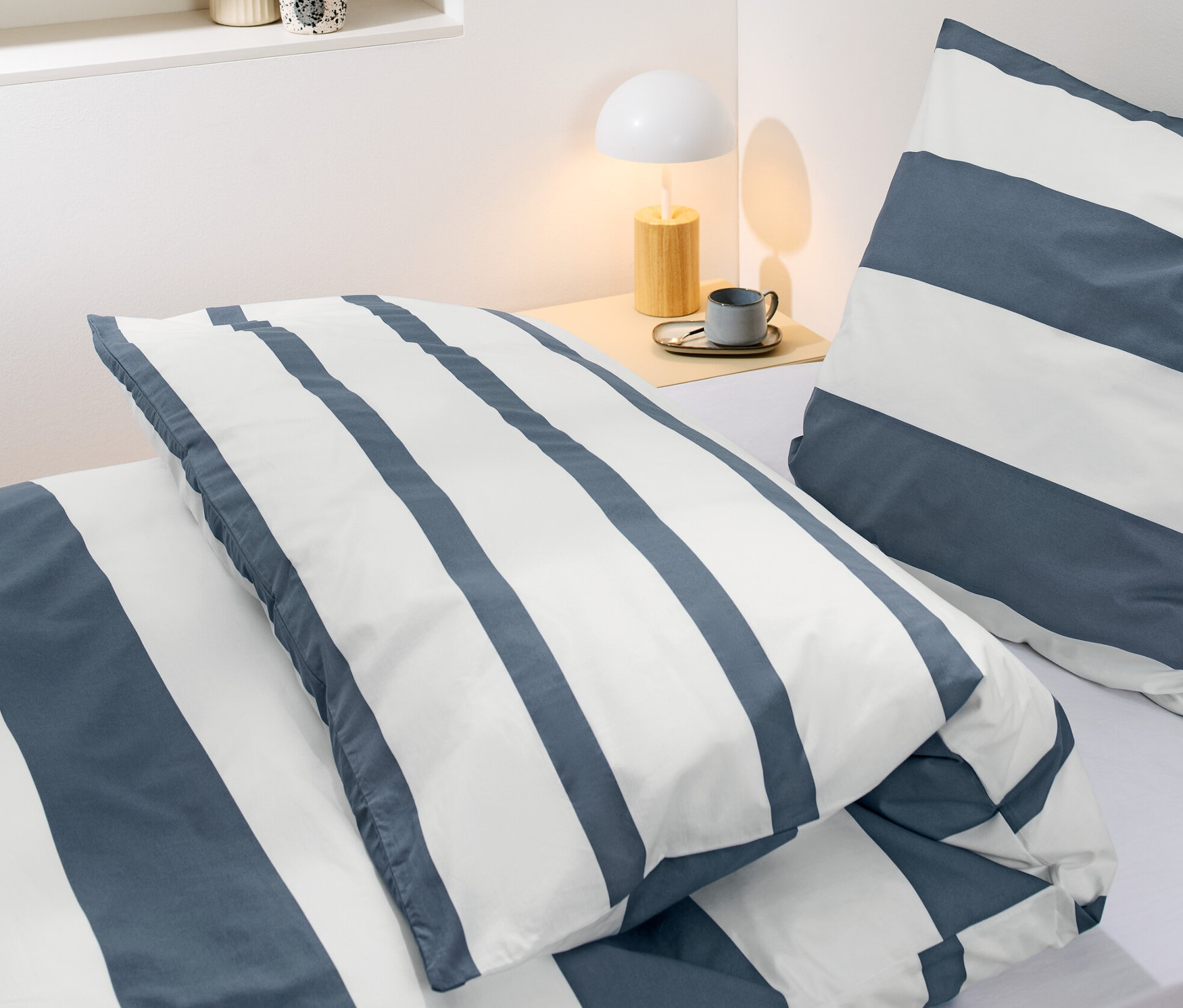 Zbliżenie na pościel perkalową w paski o standardowym rozmiarze na łóżku.