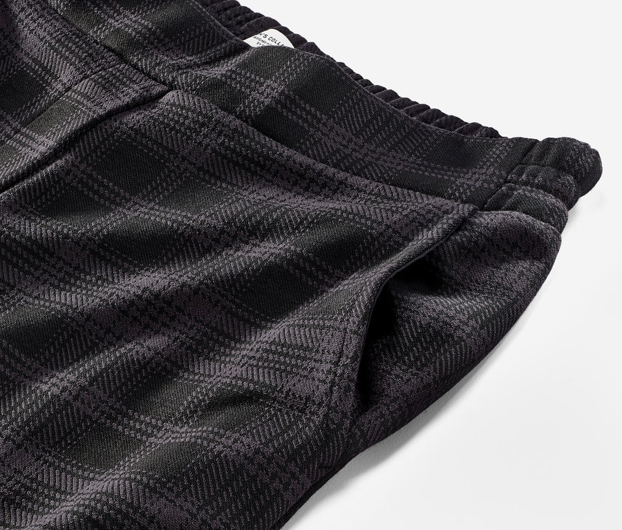 Szczegół spodni joggerów w kratę.