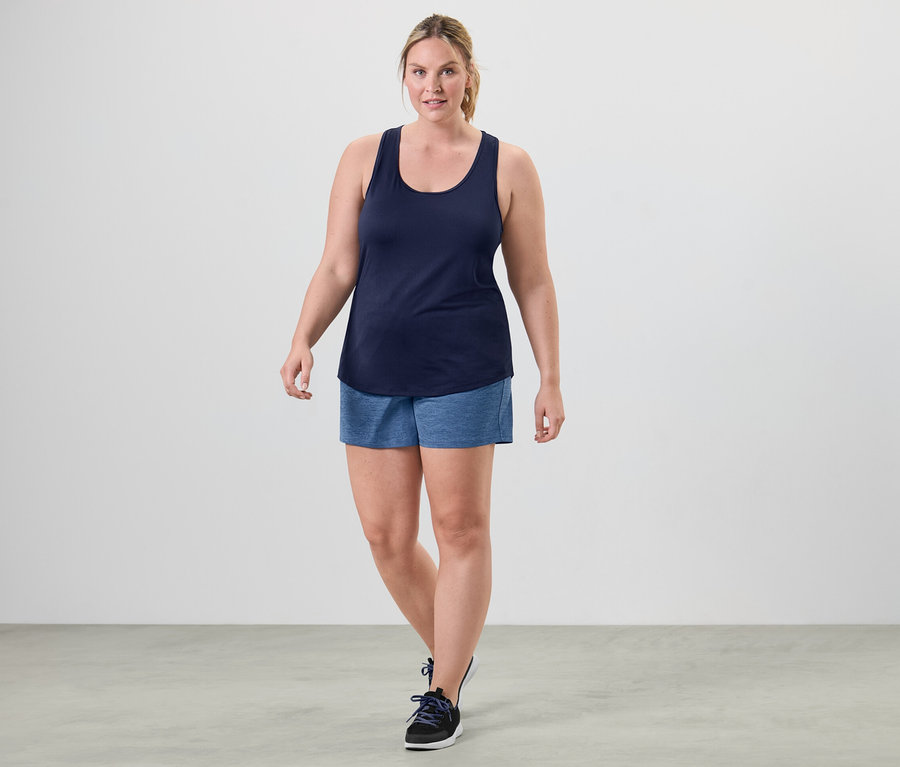 Kobieta idzie i ma na sobie jeden z topów funkcyjnych, różowy i niebieski.