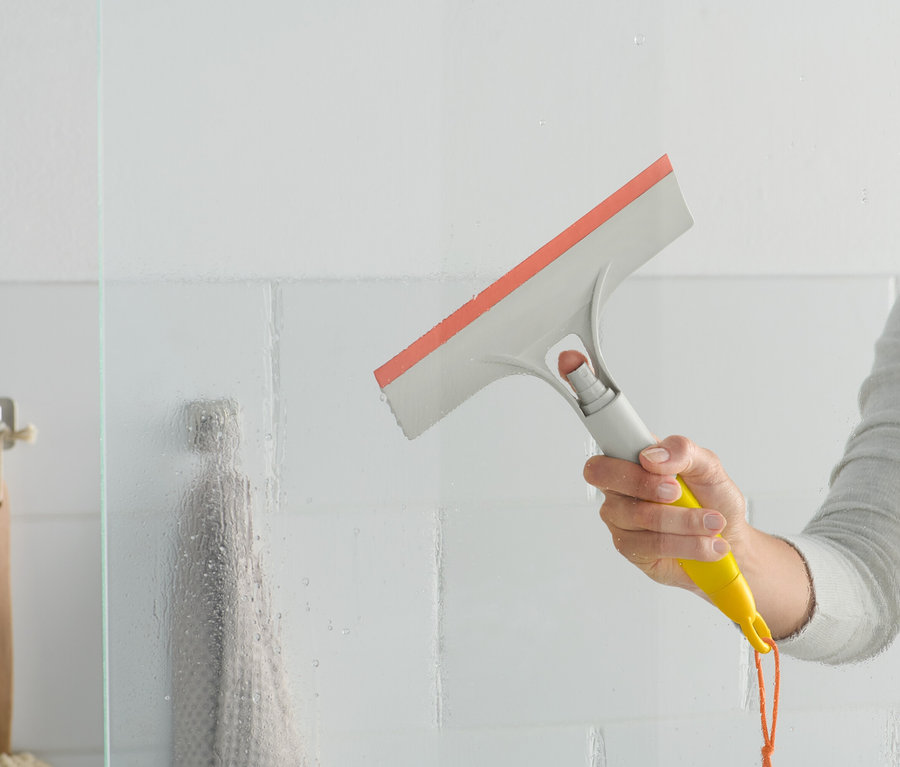 Kobieta używa myjki do szyb 3 w 1 na szklanej ściance prysznicowej.