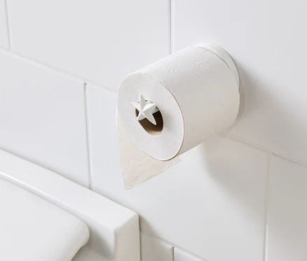 Uchwyt na papier toaletowy z papierem toaletowym na białych kafelkach.