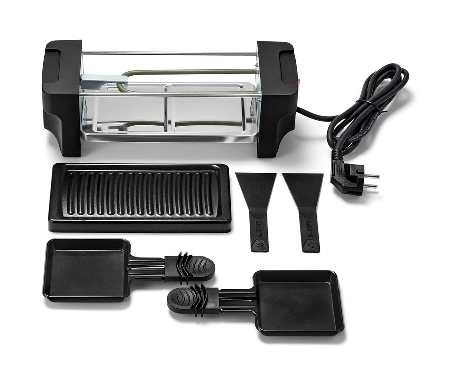 Raclette dla dwóch osób z grillem, patelniami i skrobakami.