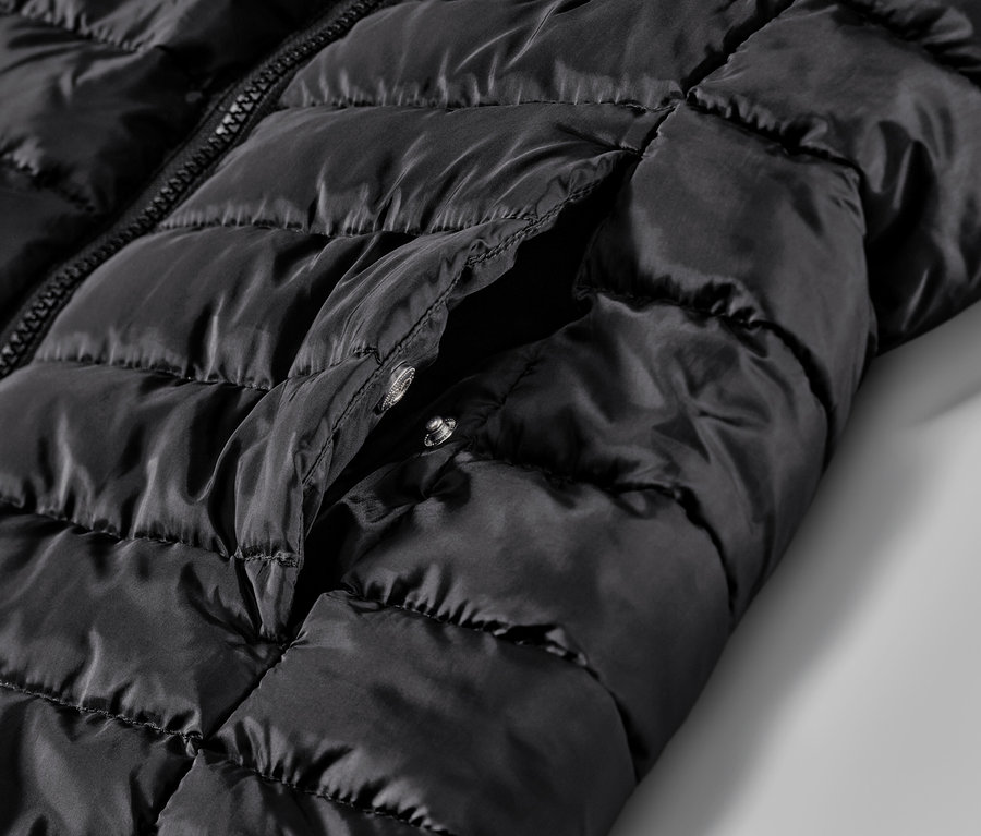 Zbliżenie na czarną, pikowaną kamizelkę z kieszenią.