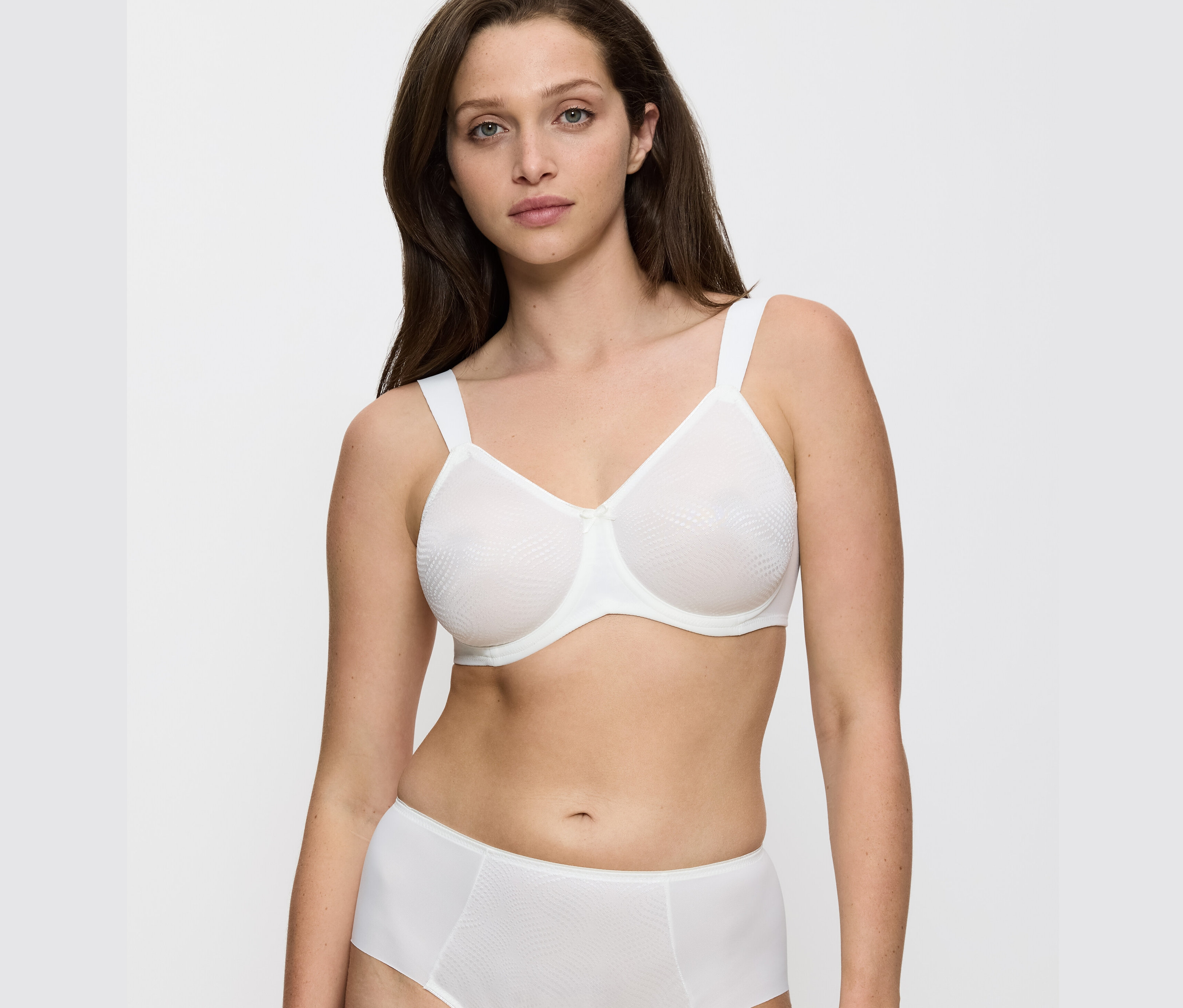 Kobieta ma na sobie biustonosz i majtki Triumph Essential „Minimizer W X” Vanille.