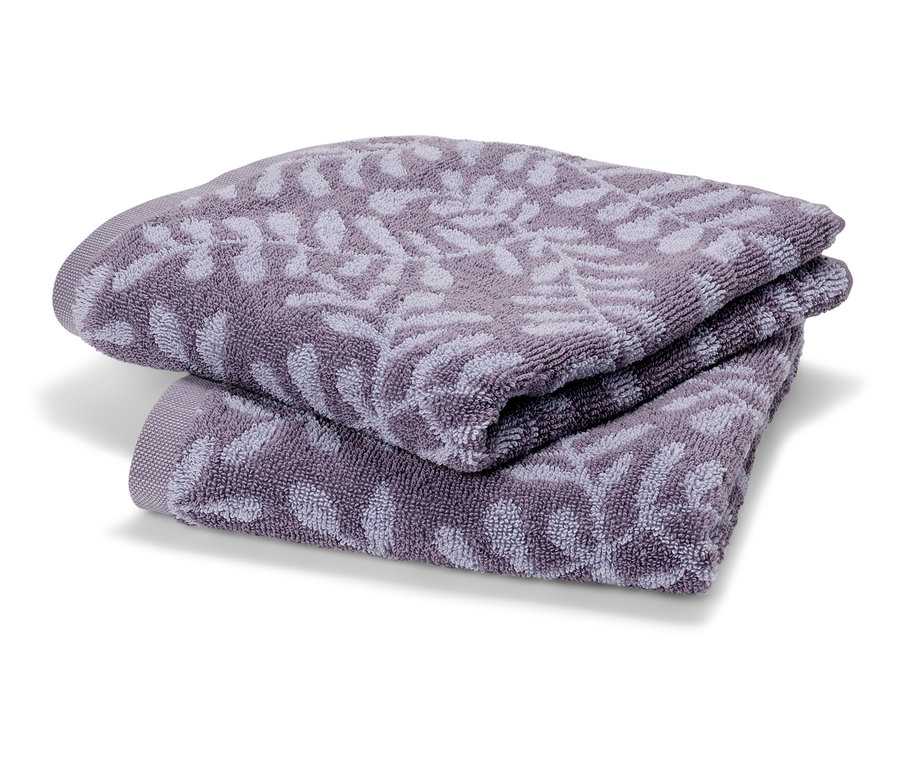 Dwa fioletowe ręczniki frotte złożone jeden na drugim. Ręczniki mają delikatny wzór liści.