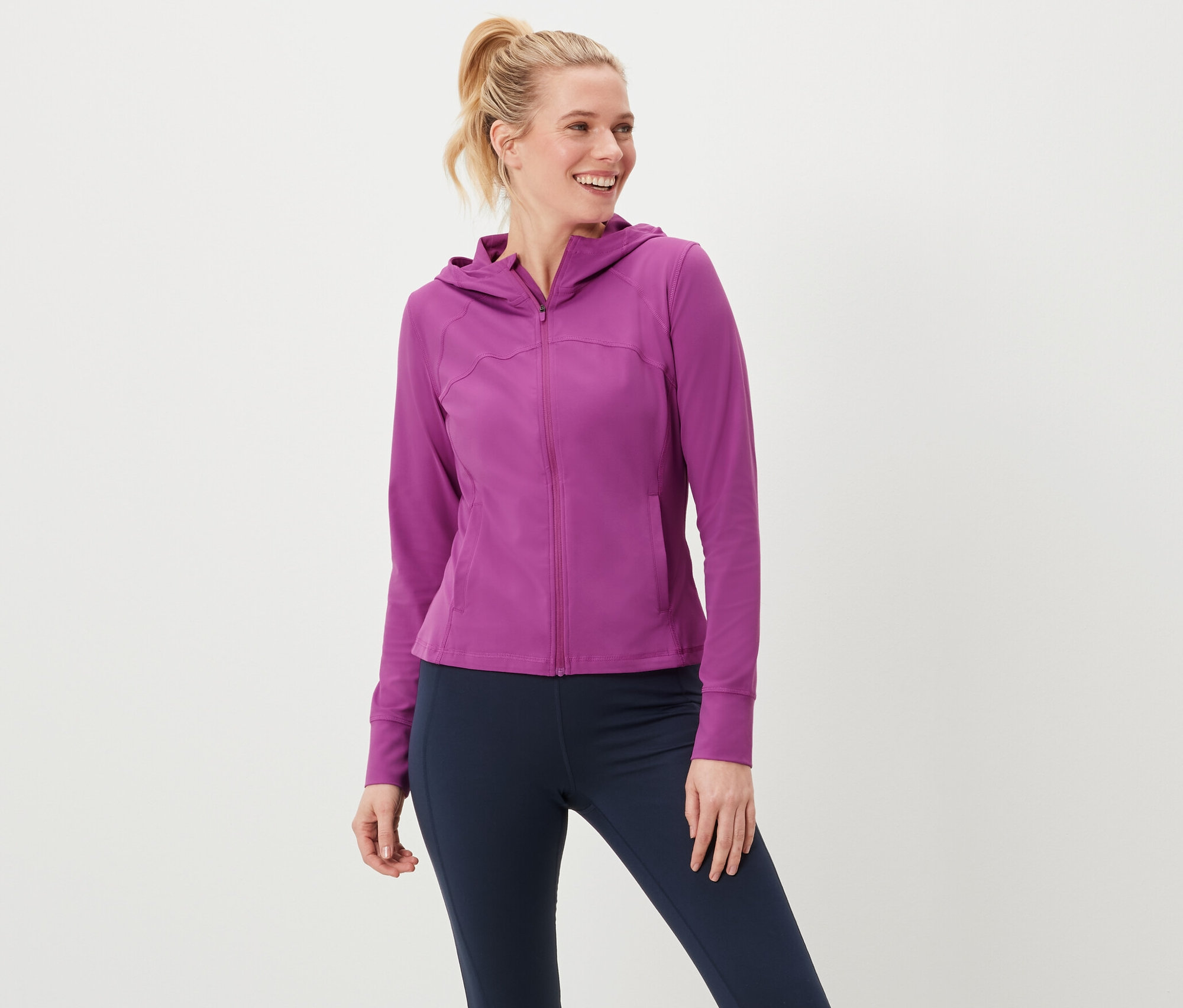 Kobieta ma na sobie bluzę sportową i legginsy.