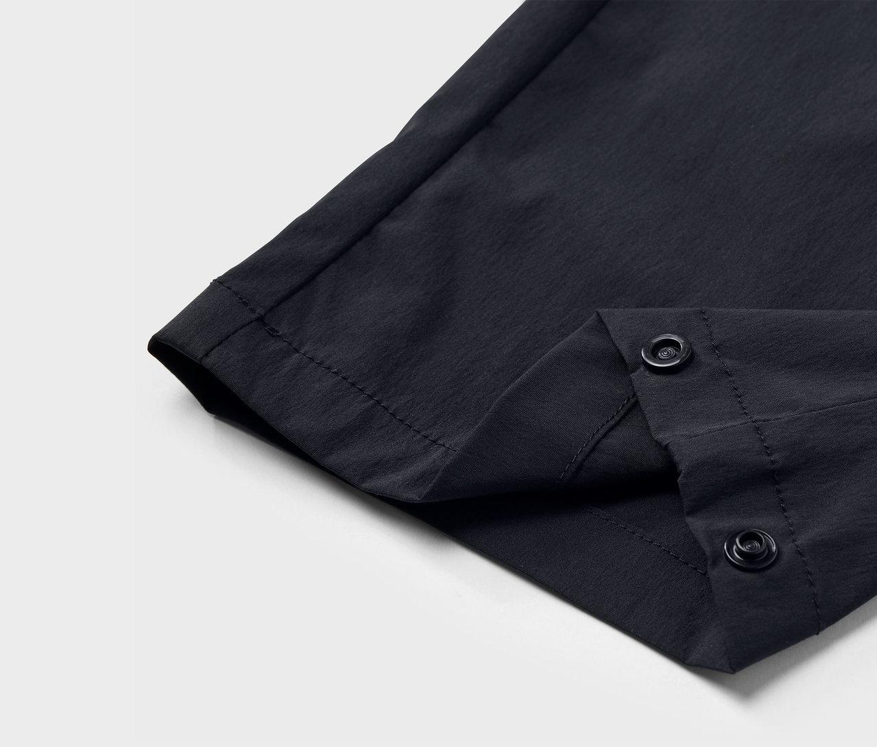 Szczegół czarnych spodni funkcyjnych zapinanych na zatrzaski.