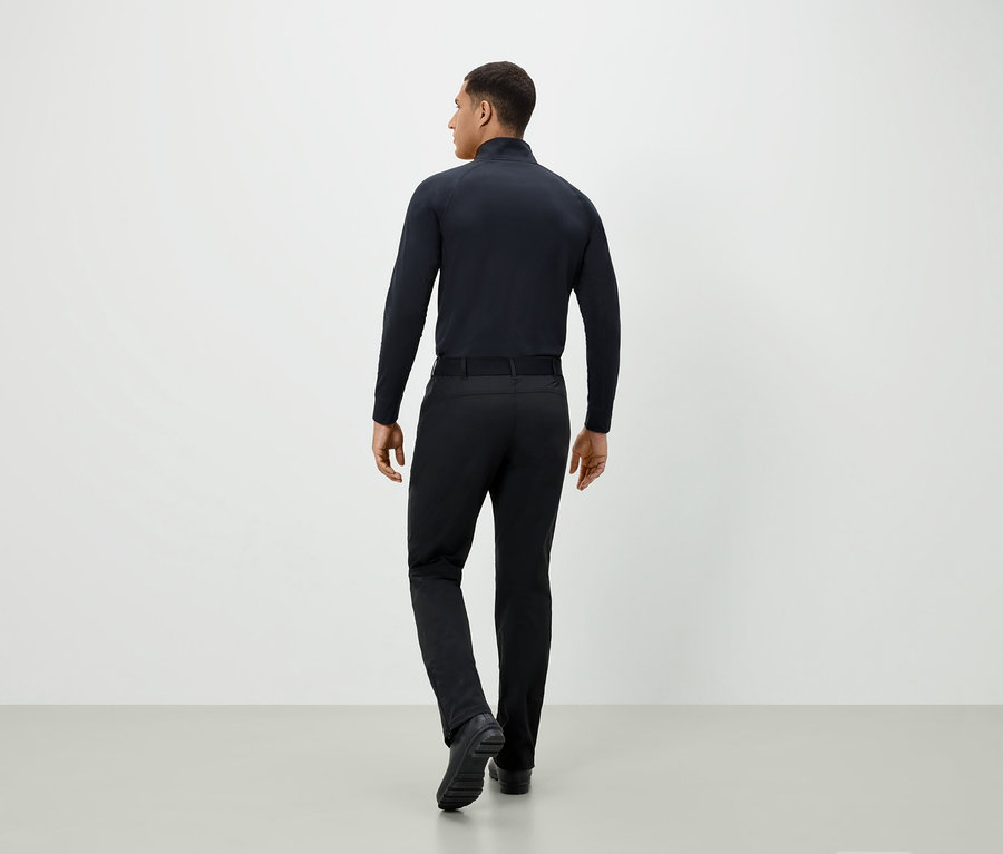 Mężczyzna w czarnym ubraniu odwrócony tyłem.