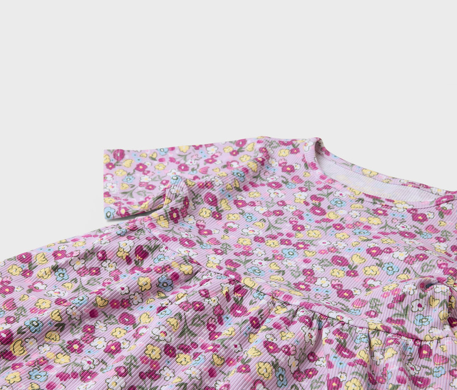 Detal fioletowej sukienki w kwiatowy wzór.