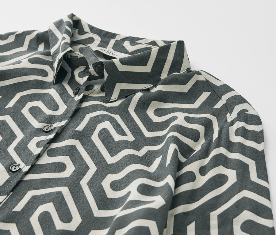 Zbliżenie na sukienkę koszulową z geometrycznym wzorem.