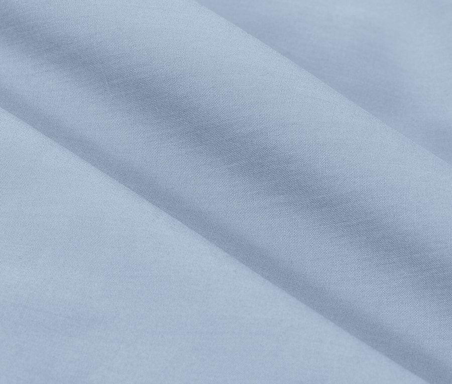 Zbliżenie jasnoniebieskiej tkaniny z delikatnymi fałdami.
