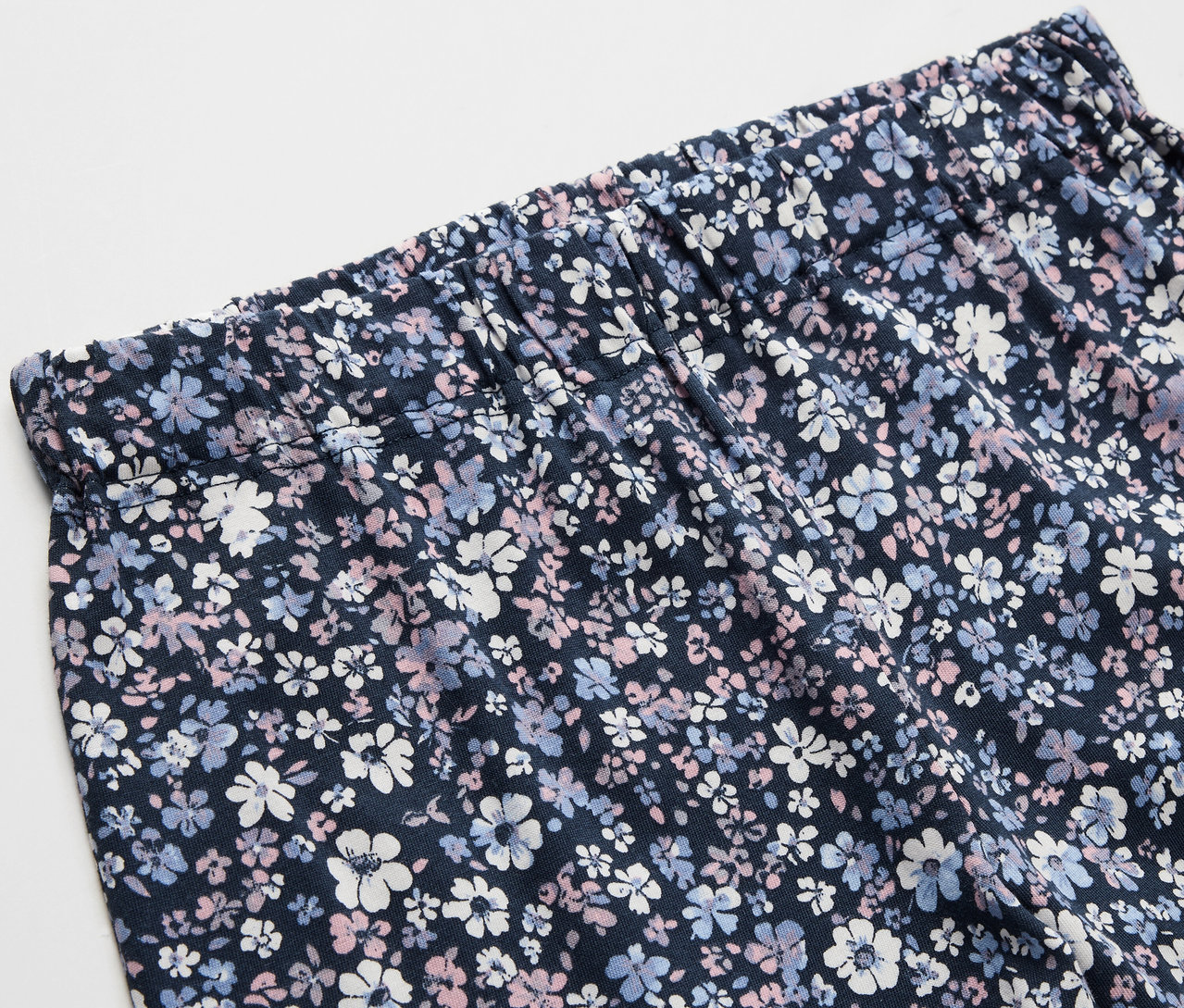 Zbliżenie na 2 dziecięce piżamy we wzór kwiatowy.