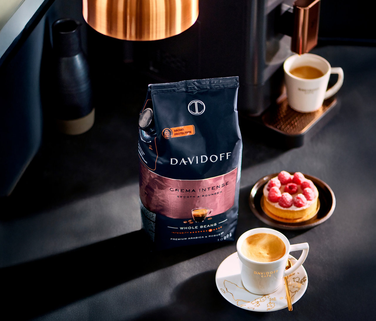 Stół z filiżanką kawy, ciastem i paczką DAVIDOFF CAFÉ Crema Intense.