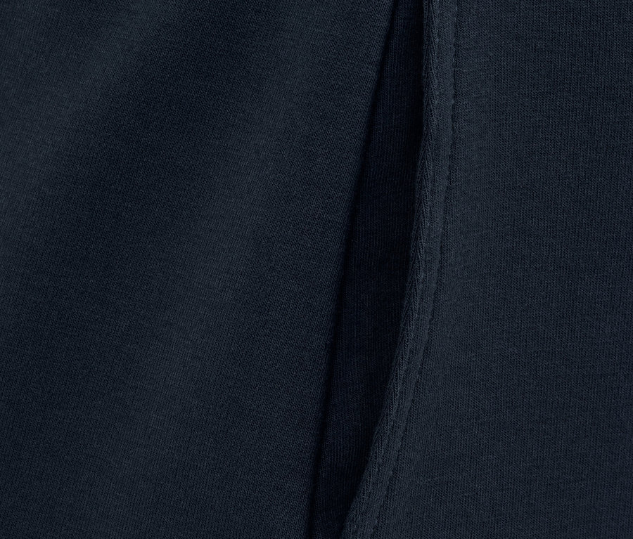 Detal granatowej spódnicy dresowej z kieszenią.