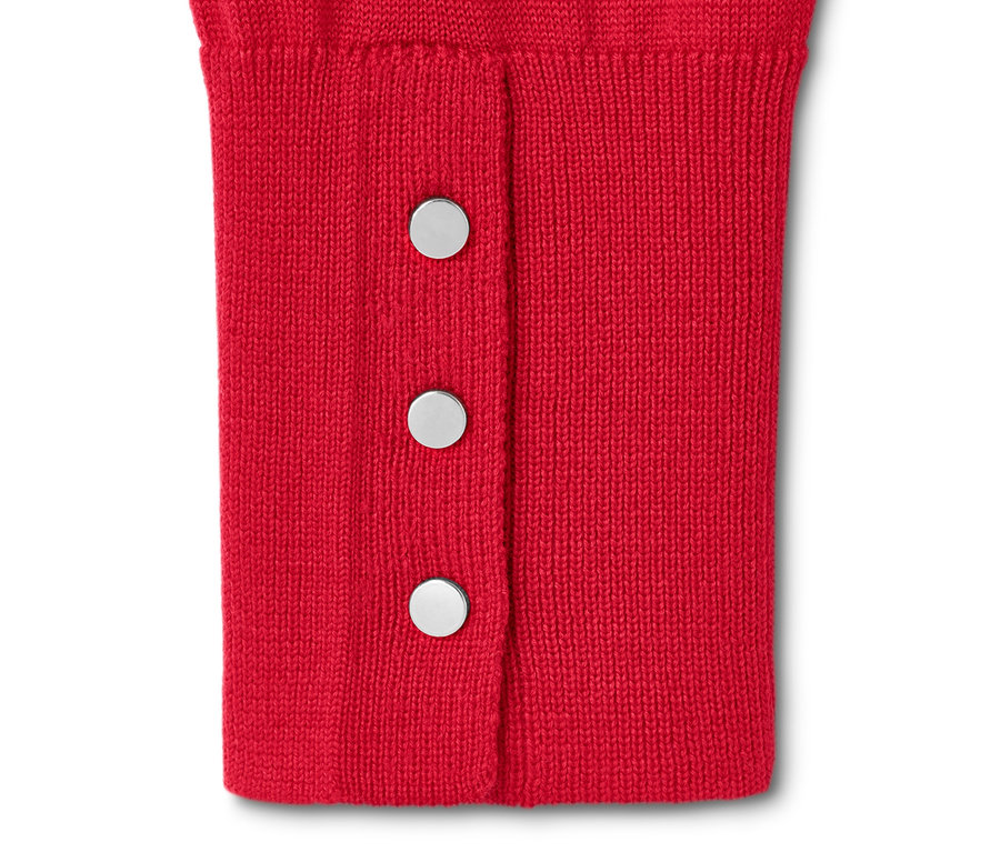Zbliżenie na czerwony sweter z delikatnej dzianiny z wełną merino, zapinany na trzy srebrne guziki.