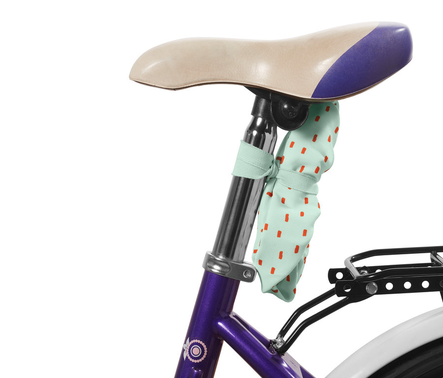 Pokrowiec na siodełko rowerowe dla dzieci w kropki przymocowany do siodełka.
