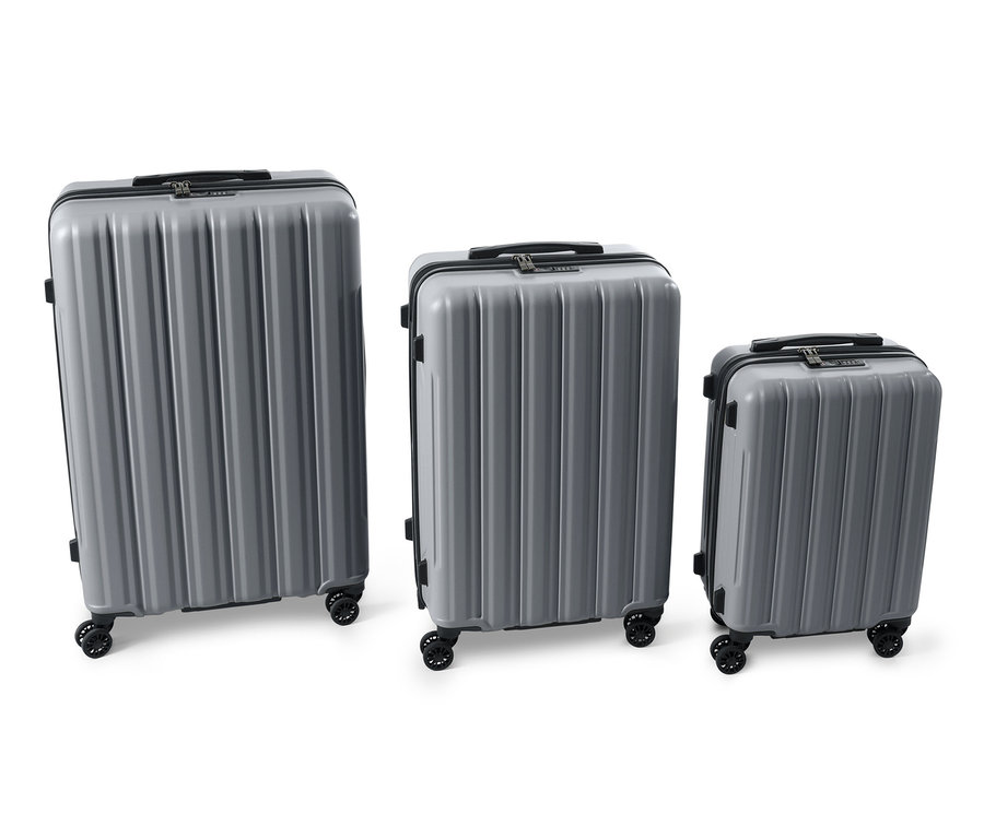 Trzy szare twarde walizki (duża, średnia i mała) stoją obok siebie na białym tle.
