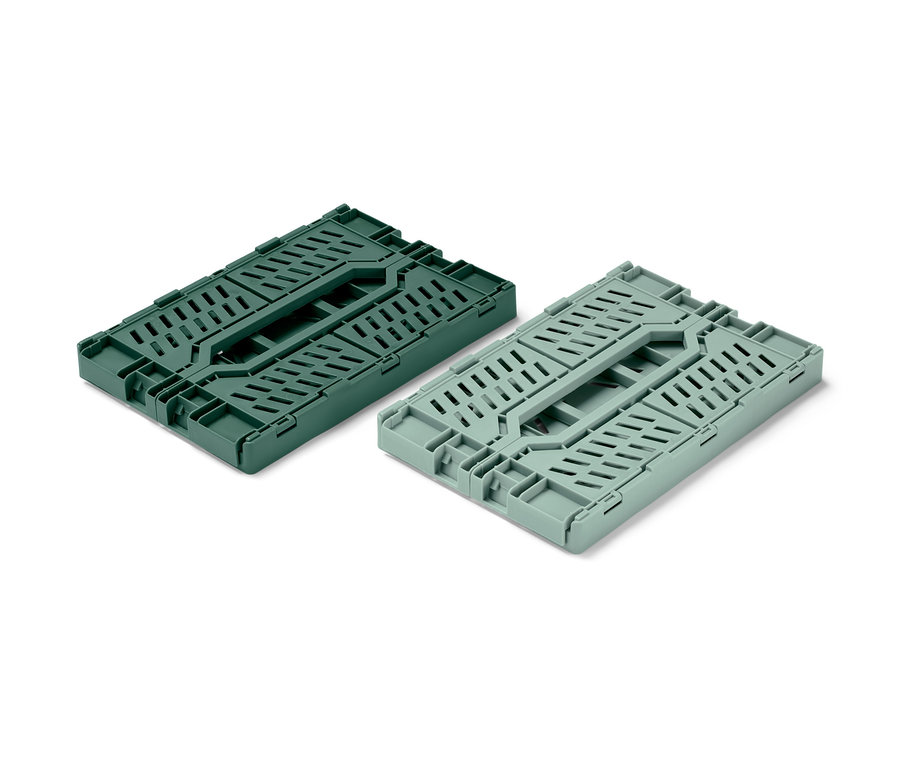 Dwa składane skrzynki do przechowywania, jeden ciemnozielony i jeden jasnozielony, złożone na białym tle.