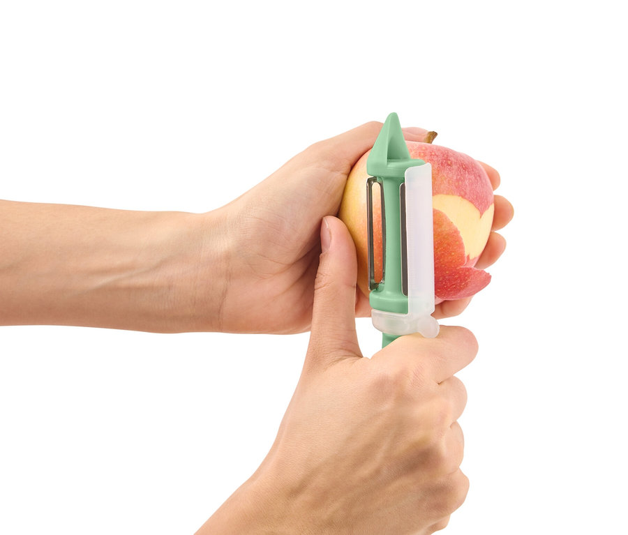 Ręce obierają jabłko obieraczką uniwersalną 2 w 1.
