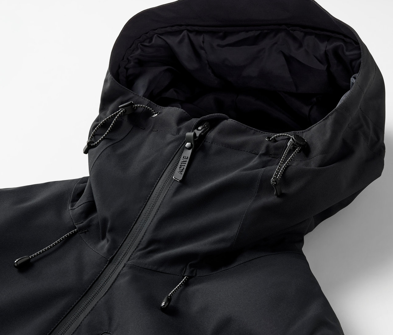 Zbliżenie na czarną kurtkę z kapturem i zamkiem błyskawicznym.