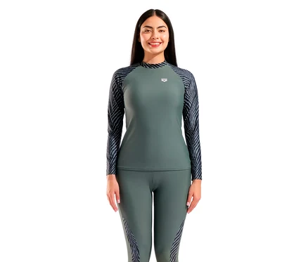 Kobieta ma na sobie oliwkowozielony top sportowy z długim rękawem i legginsy z wzorem zebry na rękawach i po bokach.