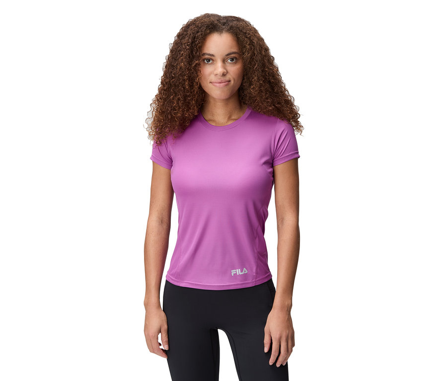 Kobieta ma na sobie fioletową koszulkę sportową Fila i czarne legginsy.