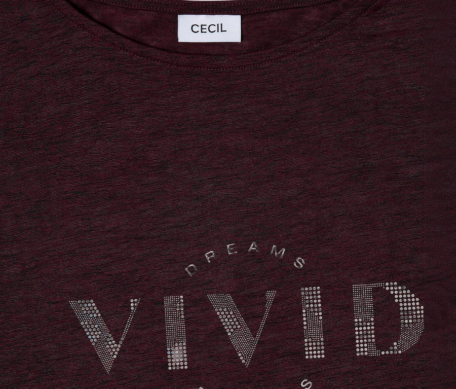 Zbliżenie bordowej koszulki CECIL z napisem „VIVID DREAMS” wykonanym ze srebrnych dżetów.