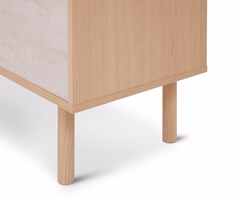 Dolny róg mebla z jasną drewnianą ramą i dwoma okrągłymi drewnianymi nogami, boczny panel z jasnego, teksturowanego materiału.