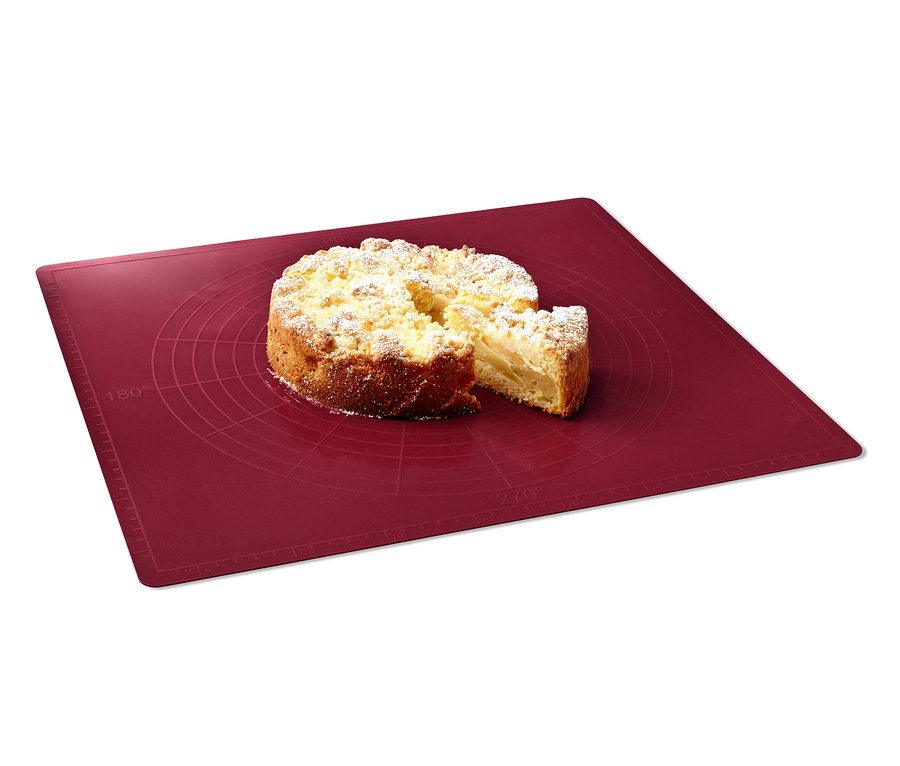 Ciasto leży na czerwonej macie do pieczenia.