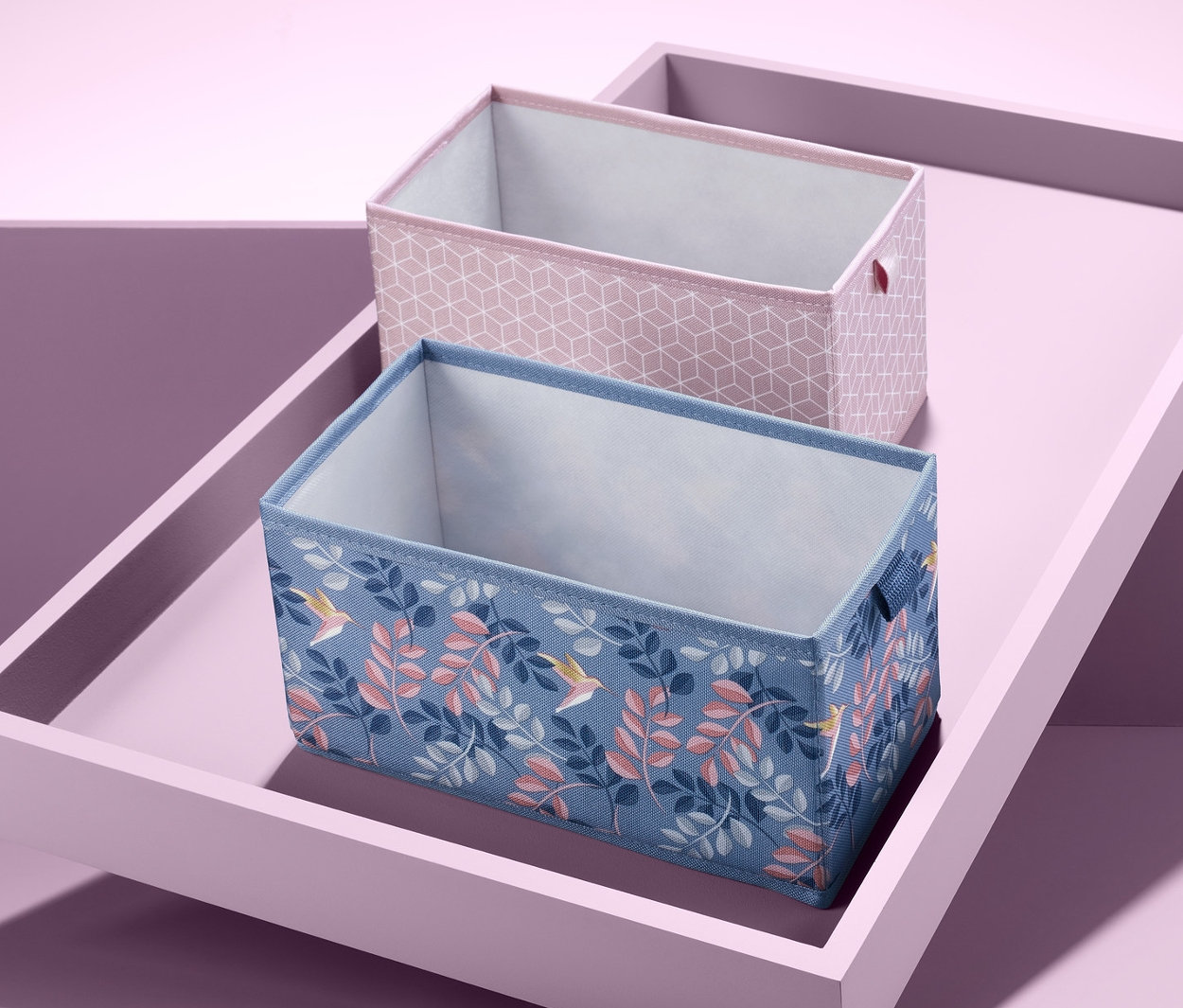 Dwa prostokątne organizery do szuflad na pochyłej tacy.