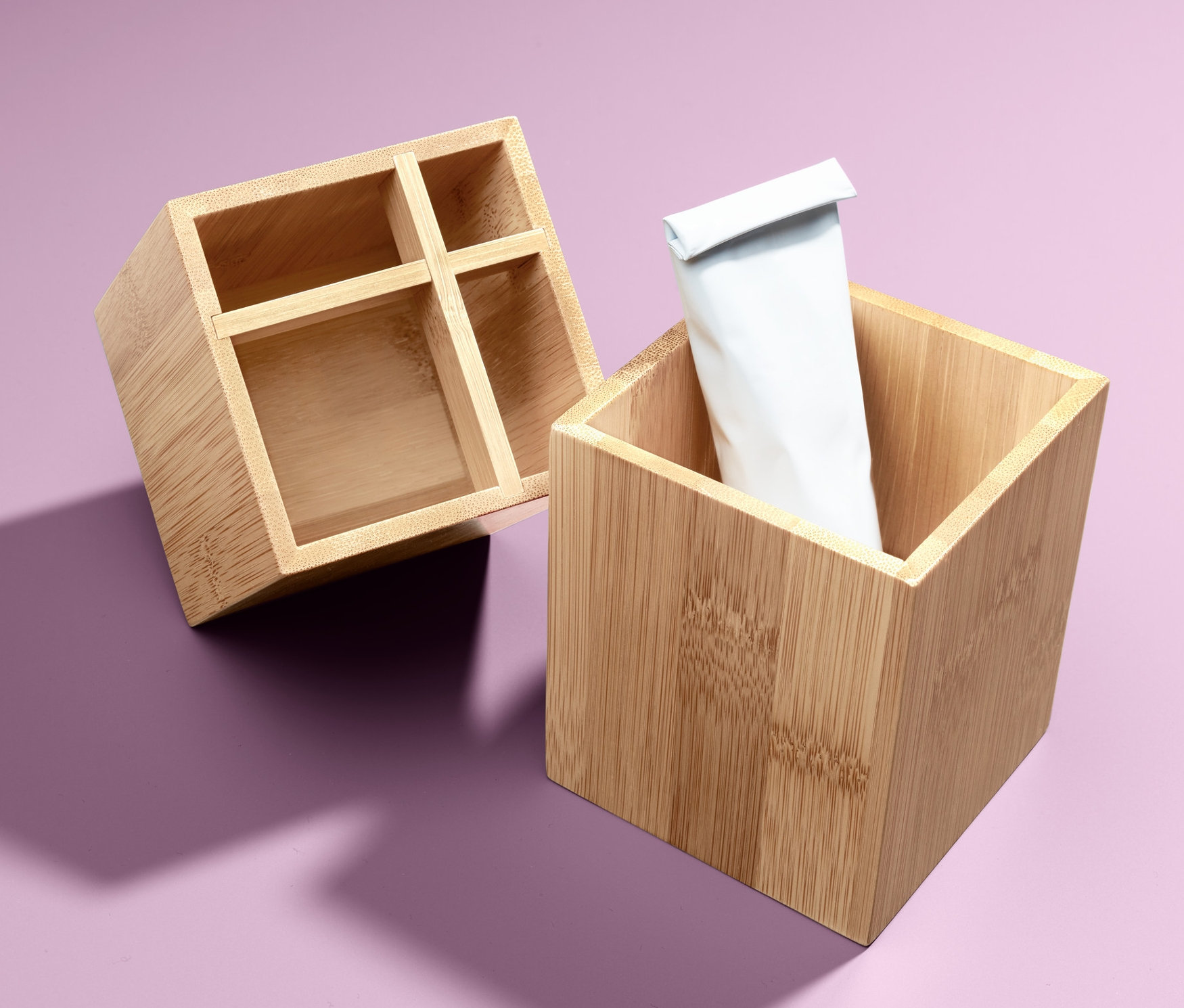 Dwa organizery na fioletowym tle, jeden pusty, drugi z białą tubą.