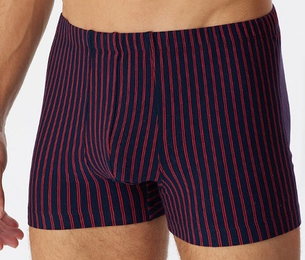 Mężczyzna nosi czerwone bokserki z bawełny ekologicznej SCHIESSER.