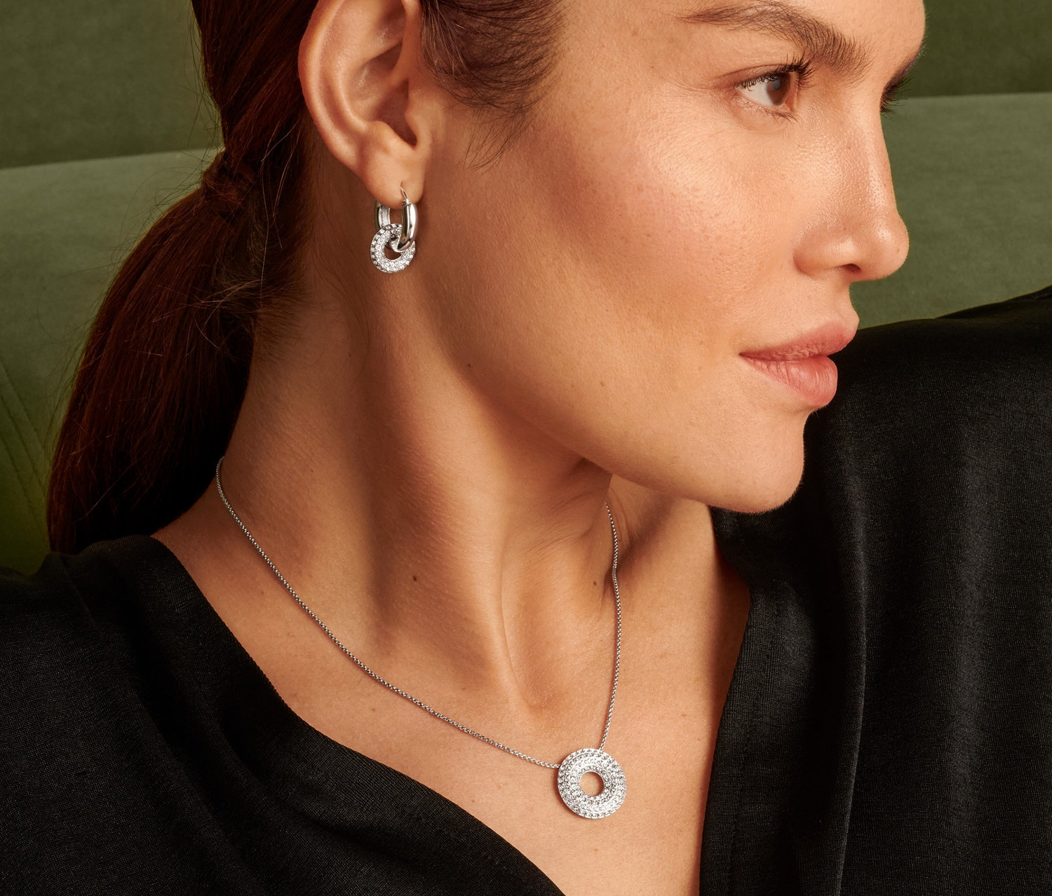 Profil kobiety z naszyjnikiem Sparkle Donut i kolczykami.