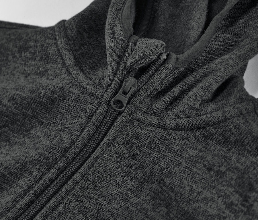 Zbliżenie na bluzę z dzianiny polarowej zapinaną na zamek.