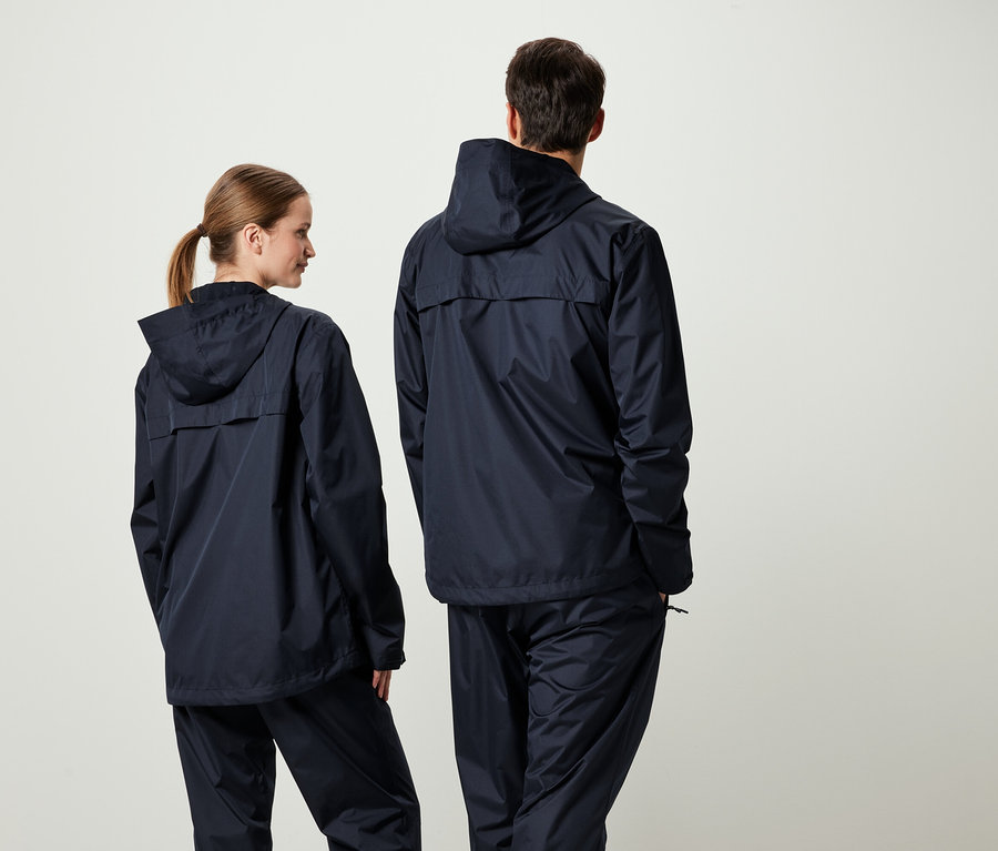 Dwie osoby tyłem do kamery w pasujących granatowych kurtkach z kapturem i spodniach.