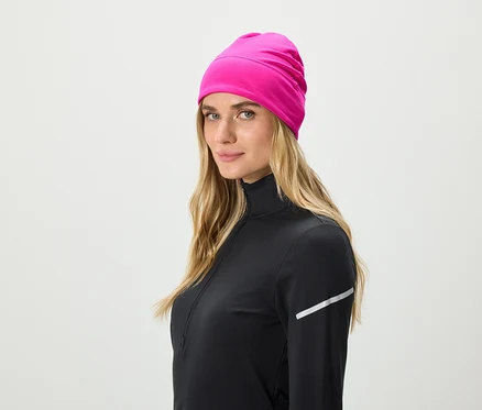 Blondynka w czarnym topie sportowym i różowej czapce.