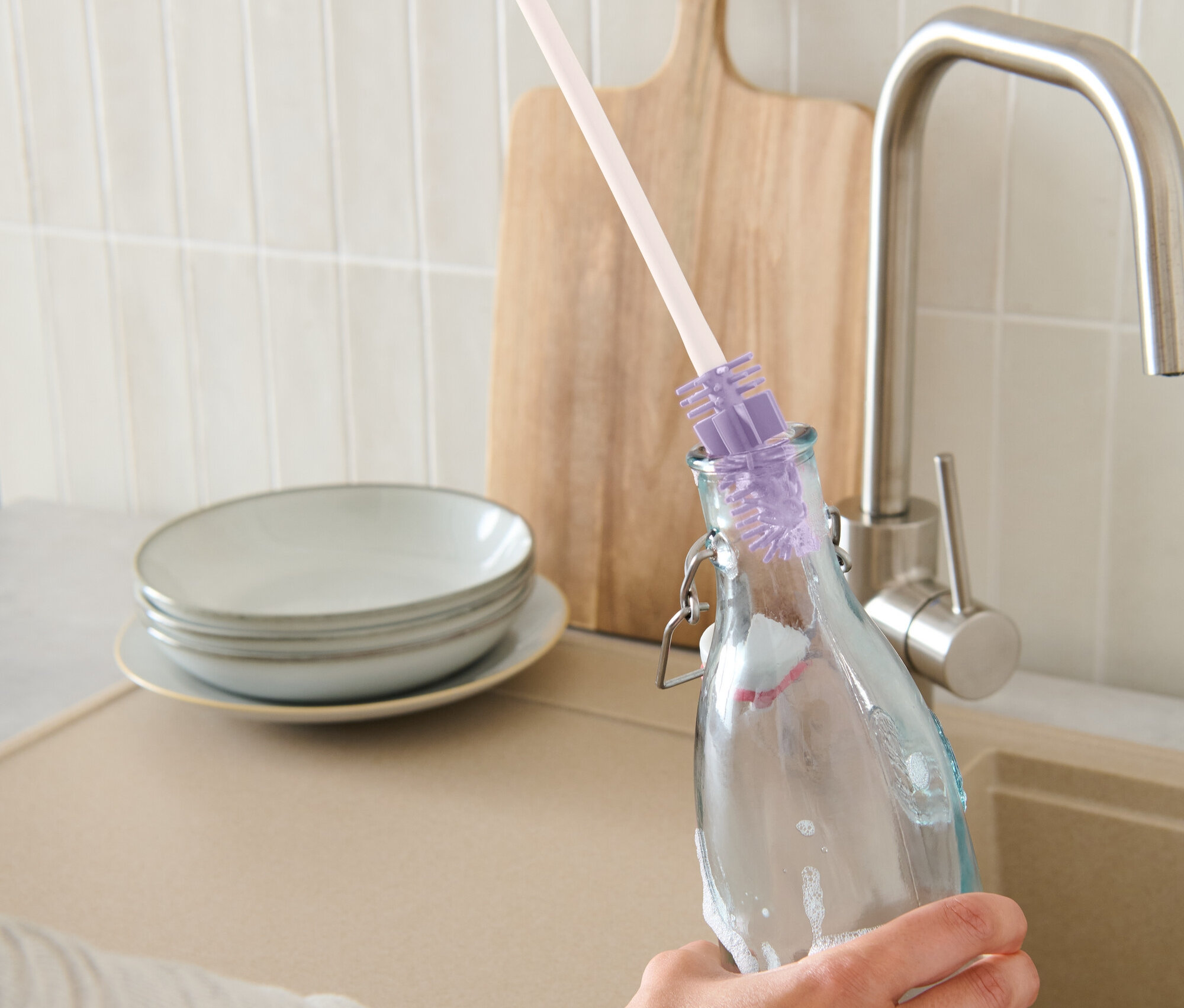 Ręka czyści butelkę szczotką do mycia butelek.