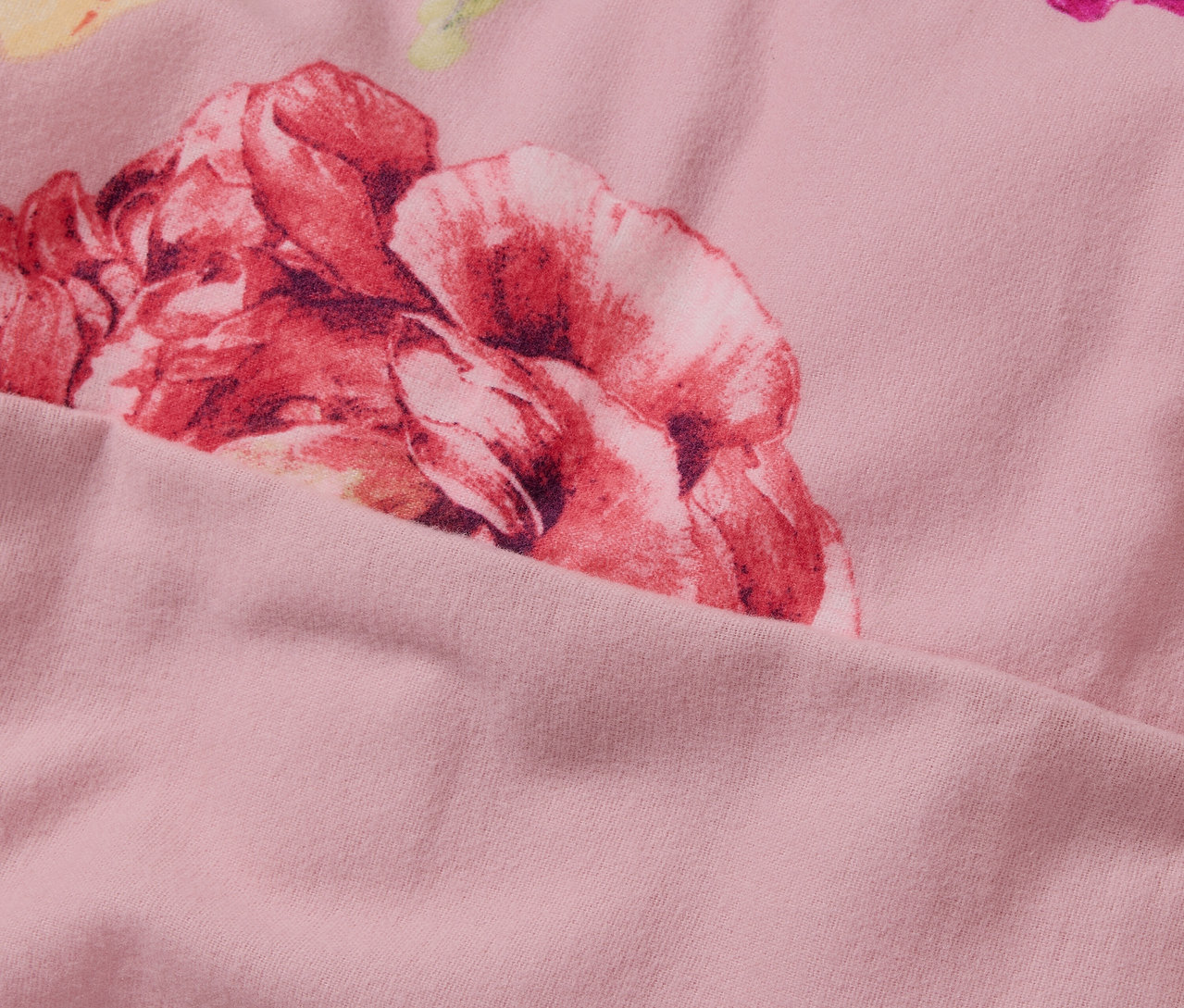 Zbliżenie na różową pościel z flaneli o standardowym rozmiarze, z kwiatowym wzorem.