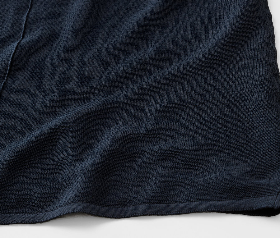 Zbliżenie na granatową bluzkę z cienkiej dzianiny.