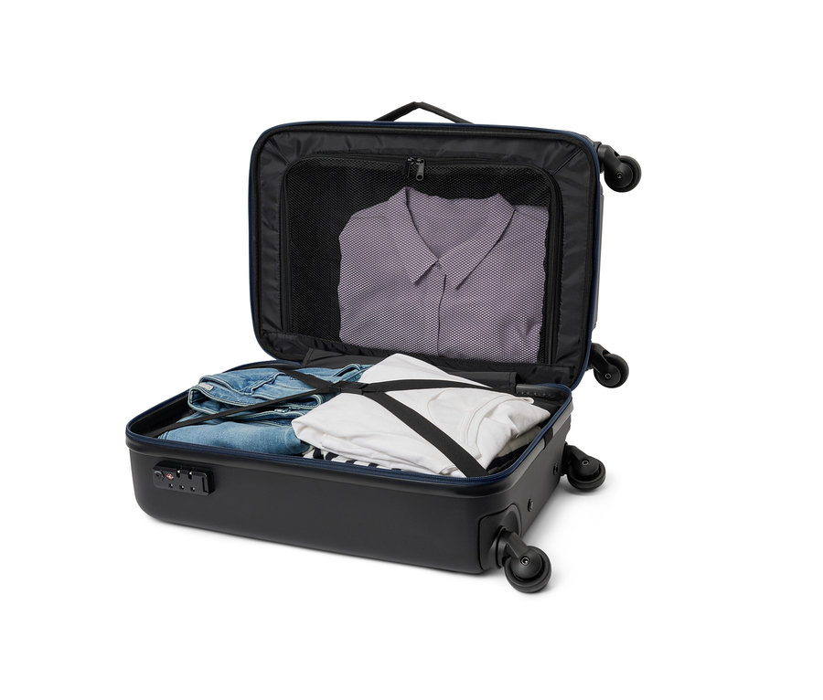 Otwarta, mała, czarna walizka hybrydowa z ubraniami w środku.