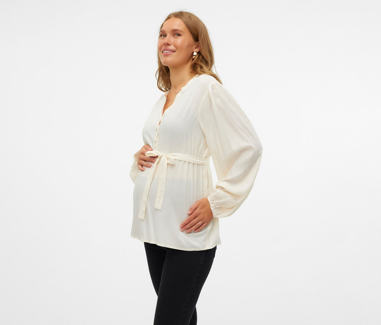 Kobieta w ciąży w bluzce MAMALICIOUS „MLMERCY LIA” i czarnych dżinsach.