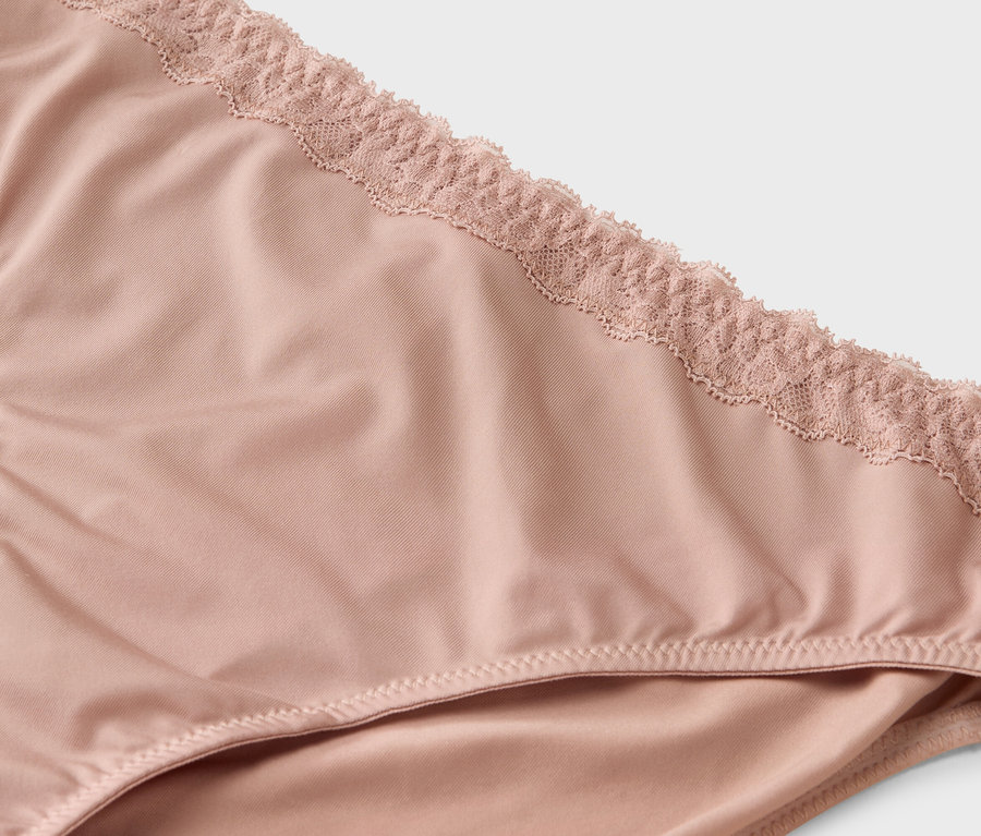 Zbliżenie na jasno-różowe majtki wykończone koronką.