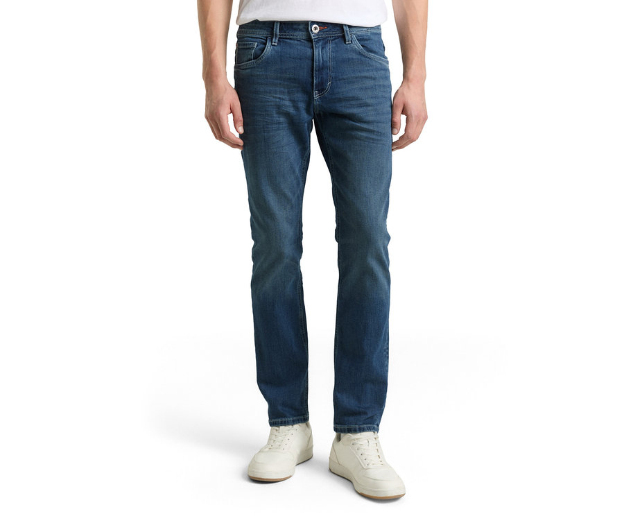Mężczyzna w dżinsach Tom Tailor TT MARVIN STRAIGHT ze stretchem, Used Mid Stone Blue Denim i białych butach.