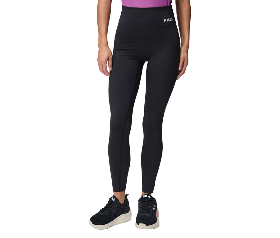 Kobieta ma na sobie czarne legginsy Fila i czarne buty sportowe.