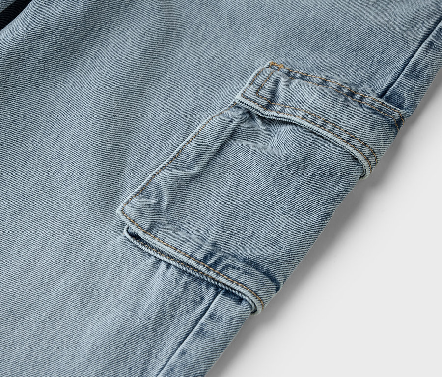 Zbliżenie na jasnoniebieskie dżinsy z kieszenią cargo.