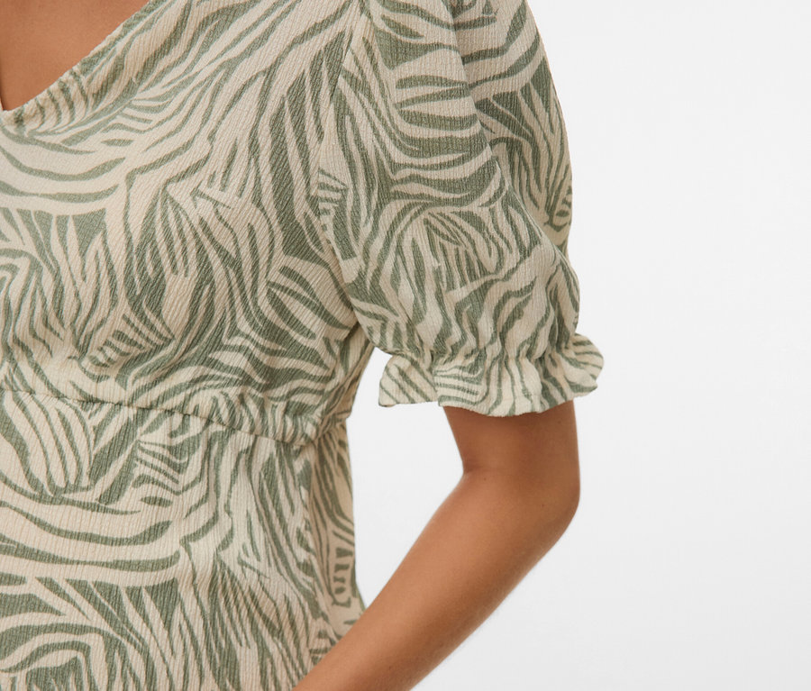 Zbliżenie kobiety w sukience w zieloną zebrę.